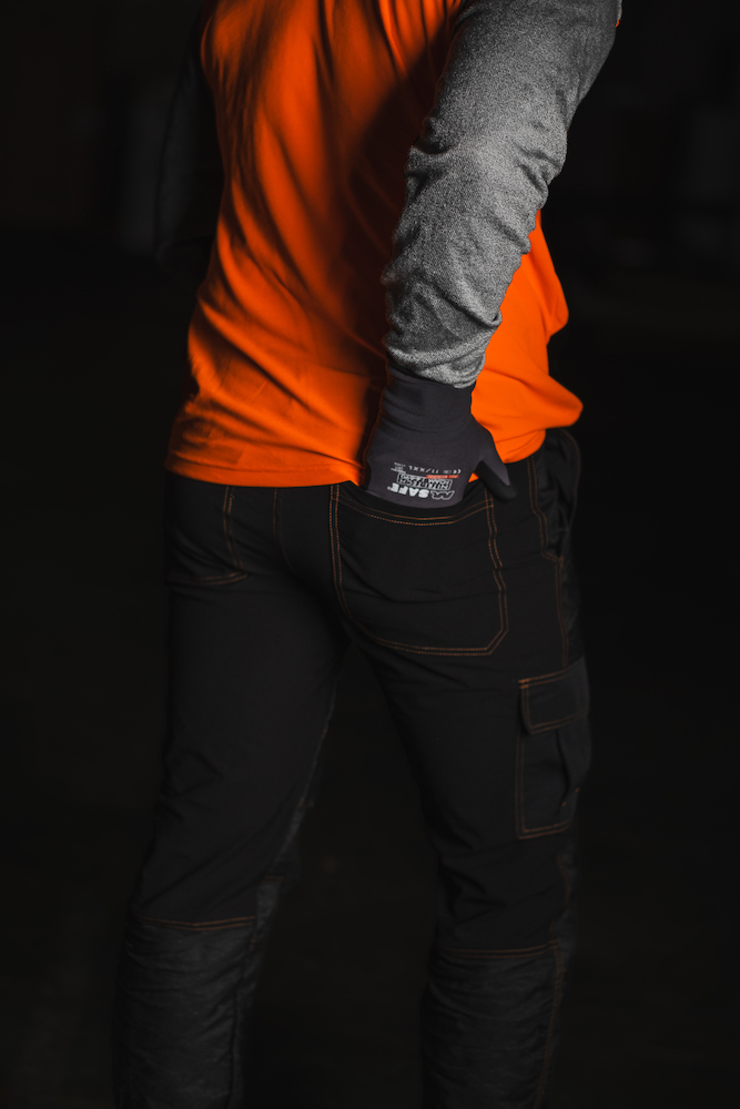 Man wearing cut resistant trousers with orange sweatshirt from PPE Factory- photography by Broodkruimel_Creations