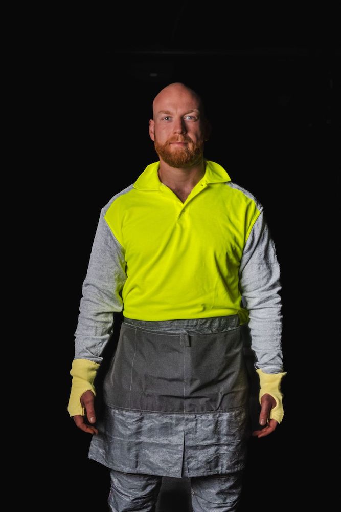 Model wearing PPE Factory polo shirt 3899 in color HiViz Yellow and apron 5070